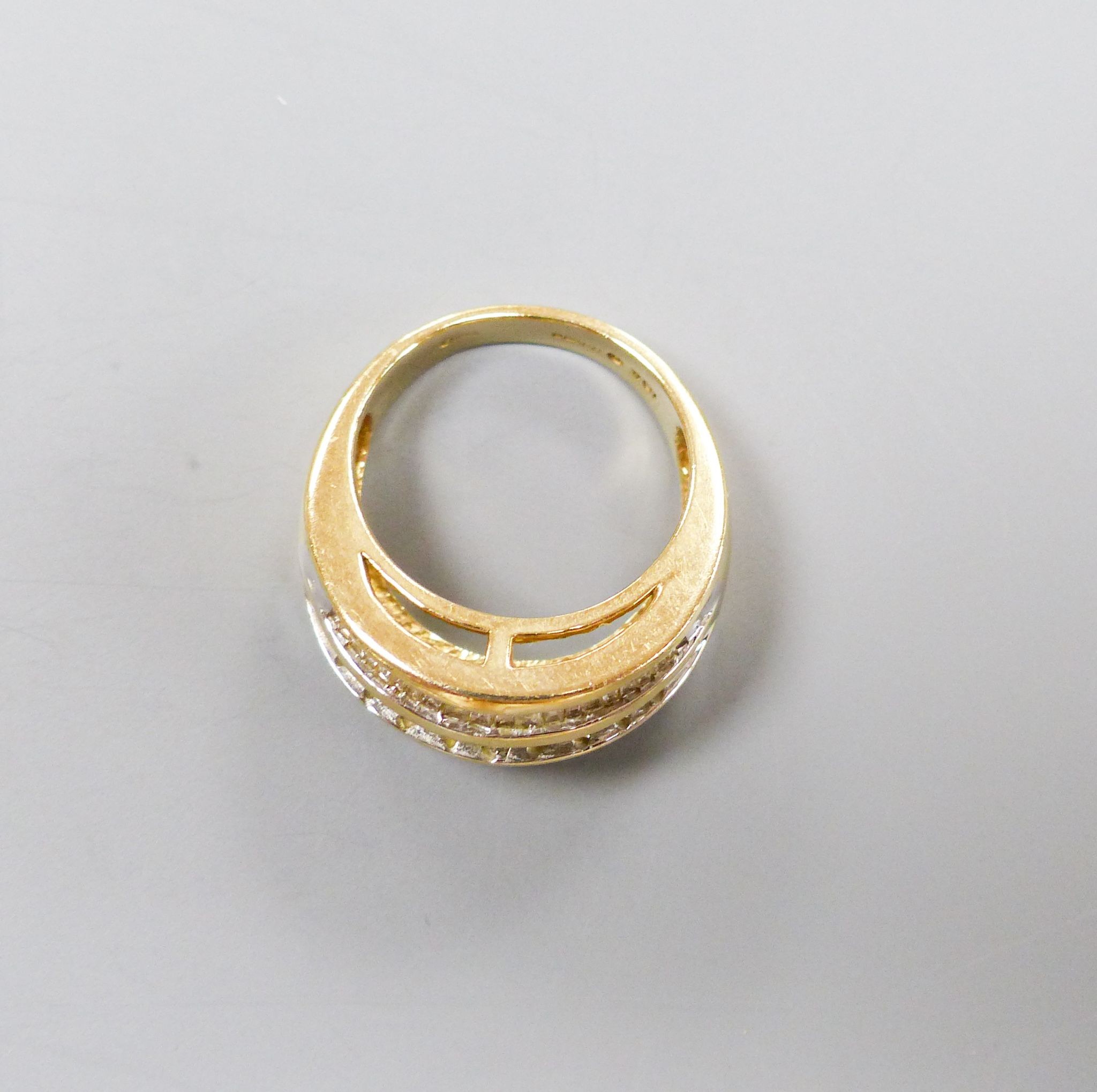 A modern 9ct gold and four row round and baguette cut diamond set dress ring, size N/O, gross 7.2 grams.